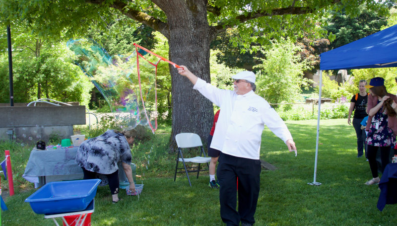 a man in a chef's costume creating a giant bubble at an event