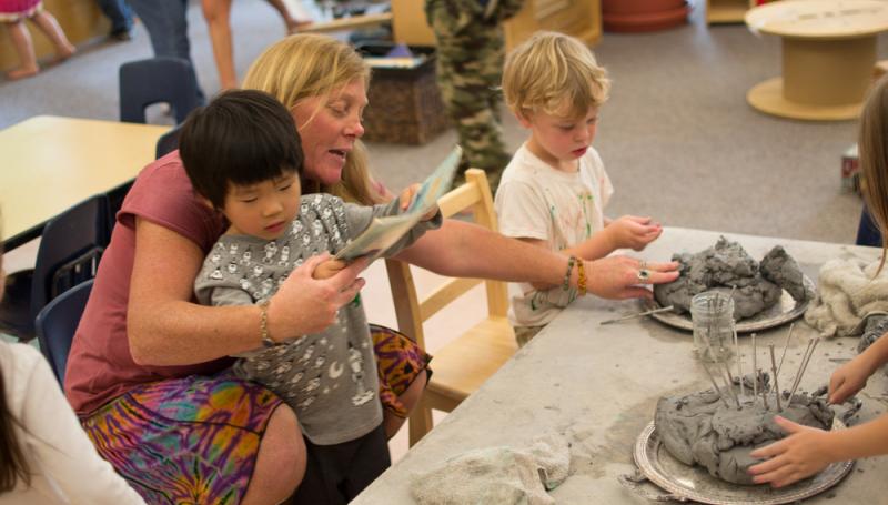 Children and teacher playing with clay