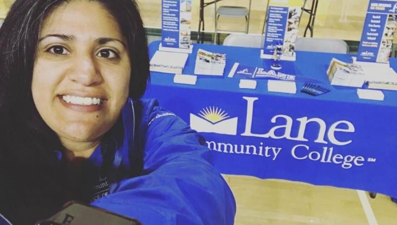 Rosa Maria at a college fair, in front of the Lane table
