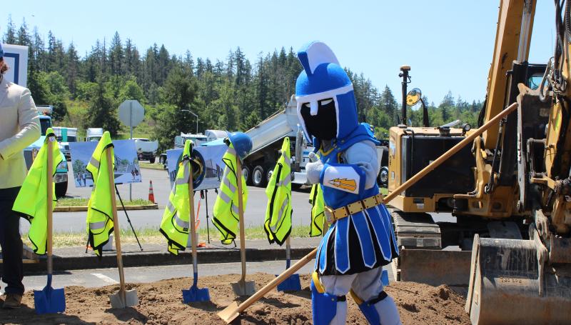 Ty the titan at a groundbreaking ceremony, holding a shovel and giving a thumbs up