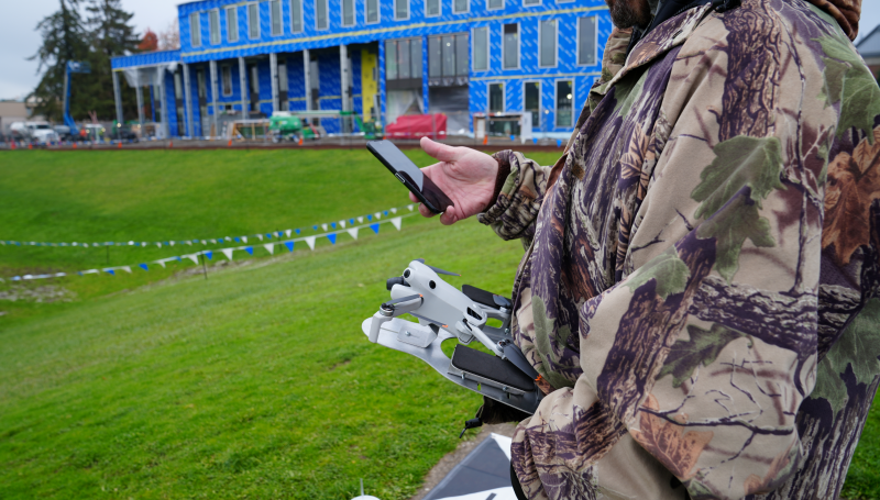 A UAS student holding a drone on the LCC soccer field