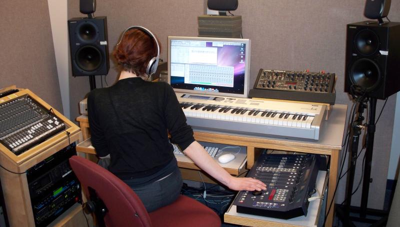 a music tech student working in an audio mastering booth