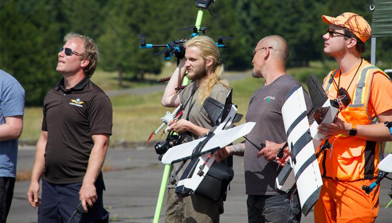 uas students holding drone gear looking up left