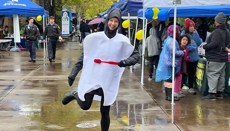 a dental instructor smiles and poses in goofy tooth costumes at the LCC open house