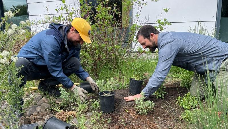Sustainability Coordinator Luis Maggiori and Earth Sciences Instructor Rick Glover smiling and planting trees on campus