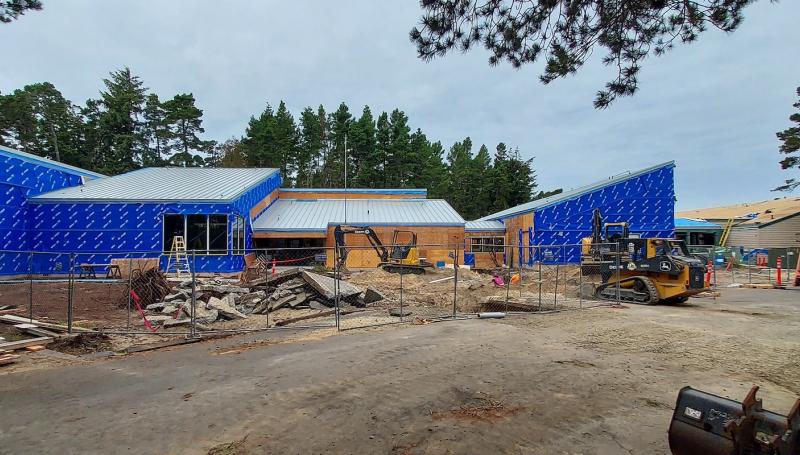 the florence center under construction with bulldozed land and the building covered with blue buildingwrap