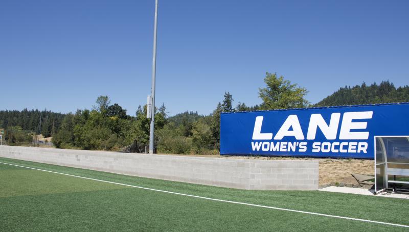 Soccer field featuring the women's team sign and the new wall