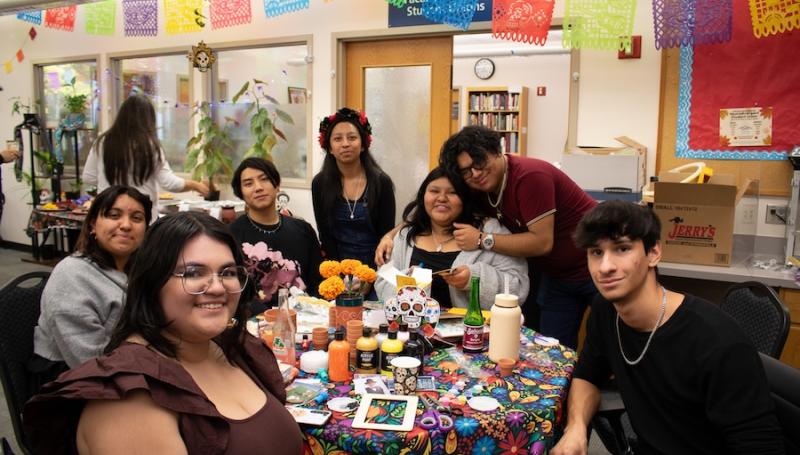 MEChA students at the Multicultural Center smiling and celebrating Dia de los Muertos