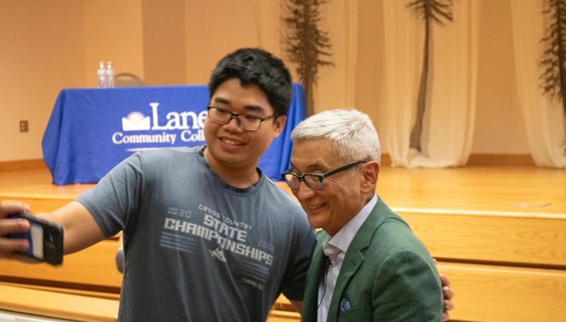 a Vietnamese young man shoots a selfie with guest speaker Bill Imada at an APISU event
