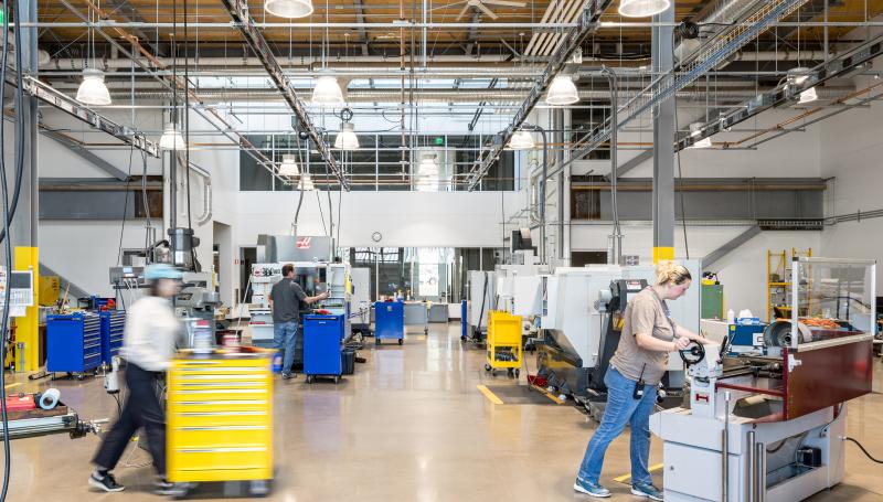 The CNC lab, with several large CNC machines being operated by students, some in motion