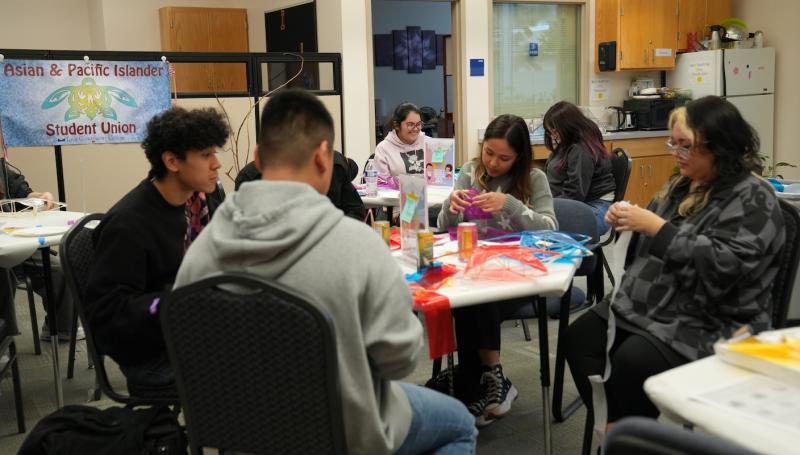 students laughing and crafting Filipino parols at an APISU event in the MCC