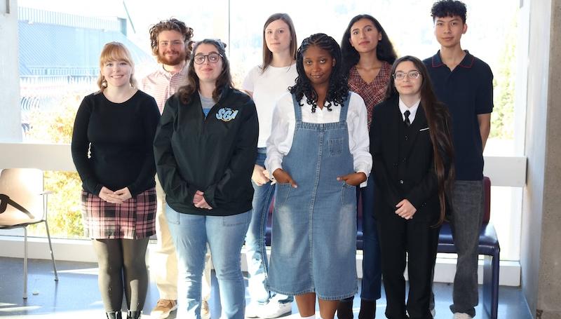 fall 2026 student goverment officials, a diverse group of students smiling by a big sunny window in Haugland Commons