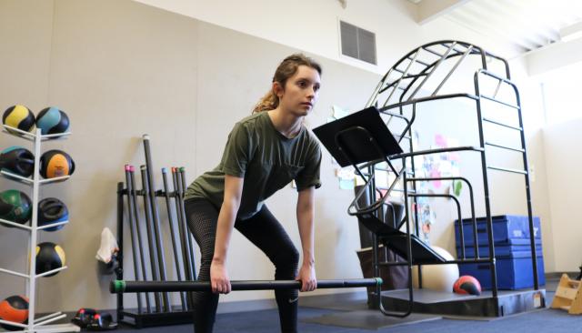 person doing a squat with a weighted bar