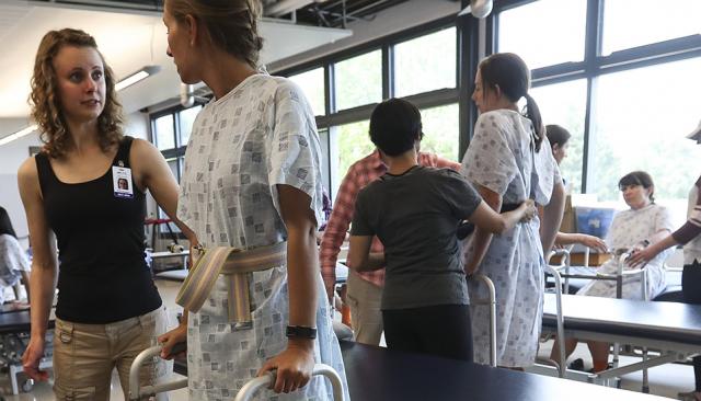 Health Professions students helping a patient