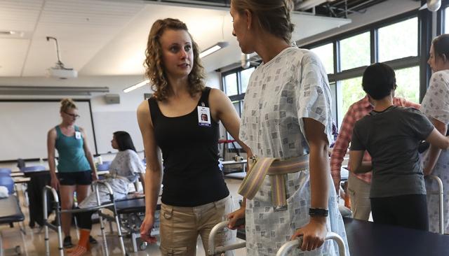 Health Professions students helping a patient