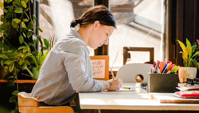 artist sitting at table working on project