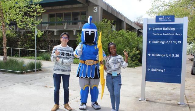 ty the titan with students in front of a sign