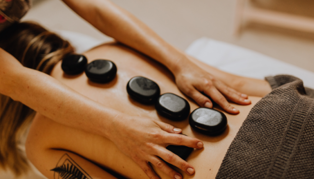 a woman with a tattoo getting a hot stone massage