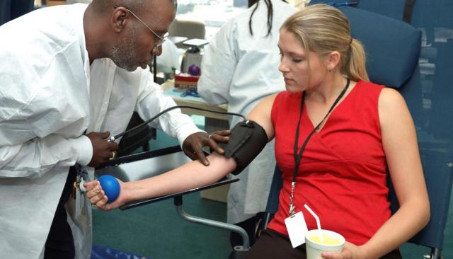 a phlebotomist draws a patients blood