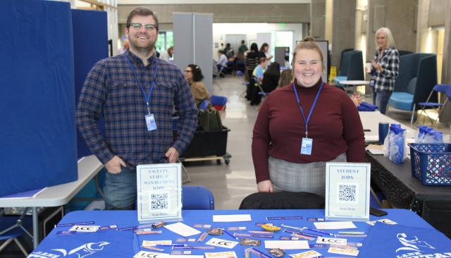 Two smiling HR employees at a college resource fair