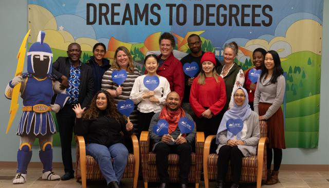 The international programs team, in front of a sign which says From Dreams to Degrees