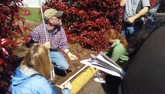 an instructor teaching sustainability in a garden bed
