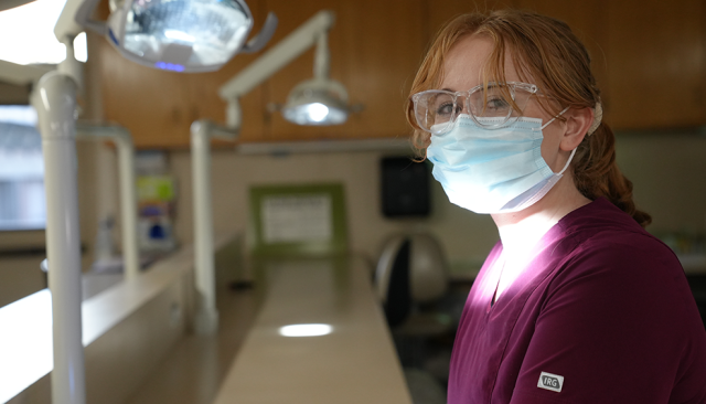 a health professions student in scrubs and a surgical mask
