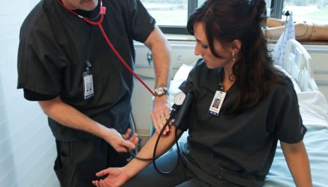 a licensed pratical nurse (LPN) student practices taking a patient's blood pressure