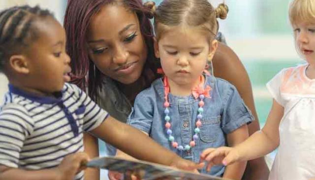 teacher reading a book to kids