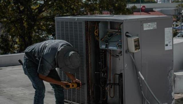 a technician installing HVAC on a roof