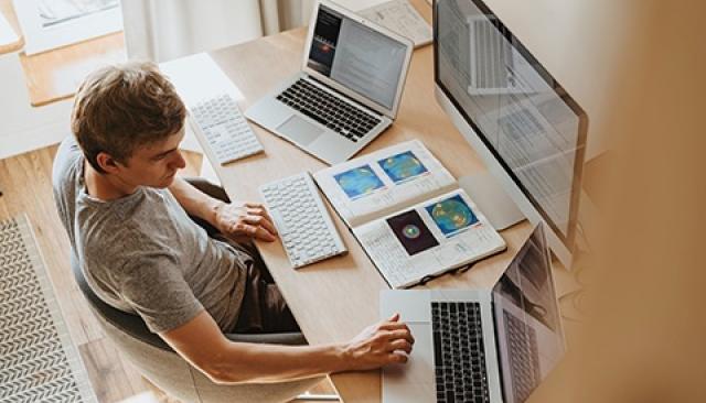 A student works at a computer in a home office