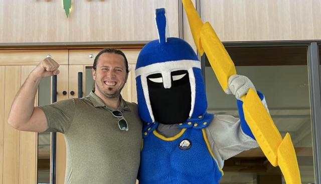 Board Member Austin Folnagy standing with Ty the Titan
