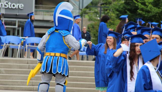 ty the titan giving a graduating student a fist bump