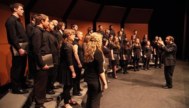 music choir in black performing on a stage
