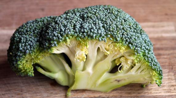 a head a broccoli on a wood table 