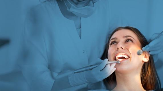A dental student at a co op internship with a smiling patient