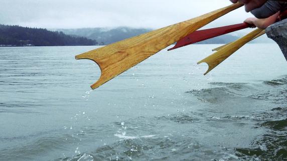 Native American paddle an ingenous boat on a Pacific Northwest lake