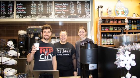 J and J Java employees smiling behind counter at cafe