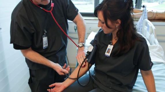 a licensed pratical nurse (LPN) student practices taking a patient's blood pressure