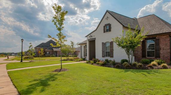 a lovely brick house with a big lawn on a sunny day