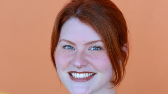 A student in scrubs with red hair