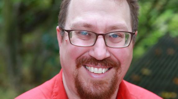A student in a red shirt and glasses