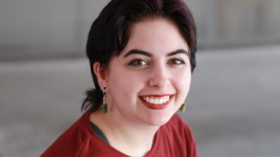A student in a red shirt and earrings