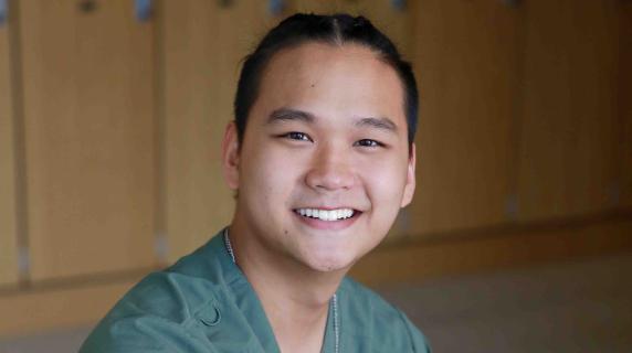 A male student in scrubs
