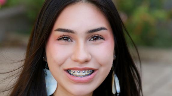 A Native American student with long dark hair and white earrings