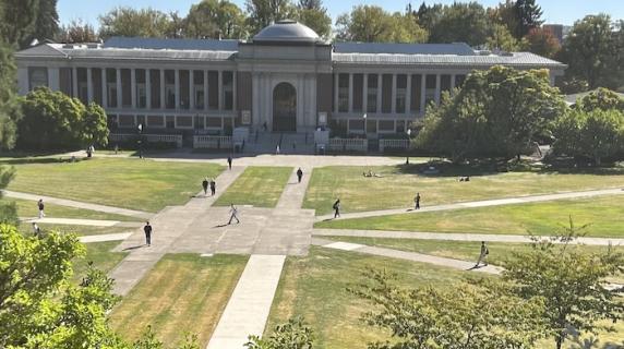A stately brick building overlucking a large grassy quad on a sunny day at the Oregon State University campus