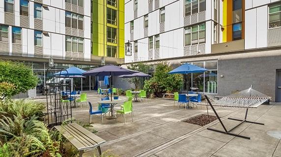 The sunny patio at Titan Court with ample seating and greenery