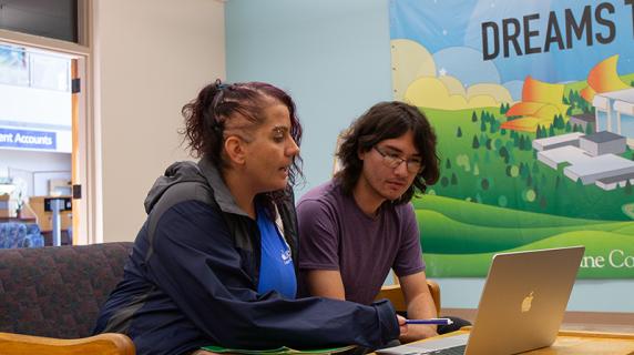 a friendly student worker in the admissions offices helps a prospective student