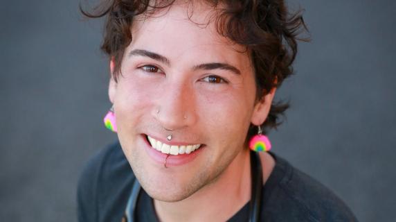 A person with bright earrings and a stethoscope
