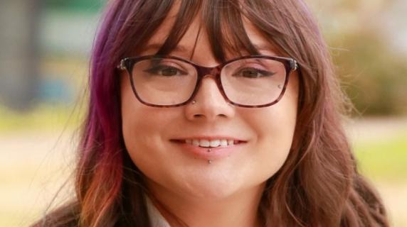 A woman with brown hair and glasses